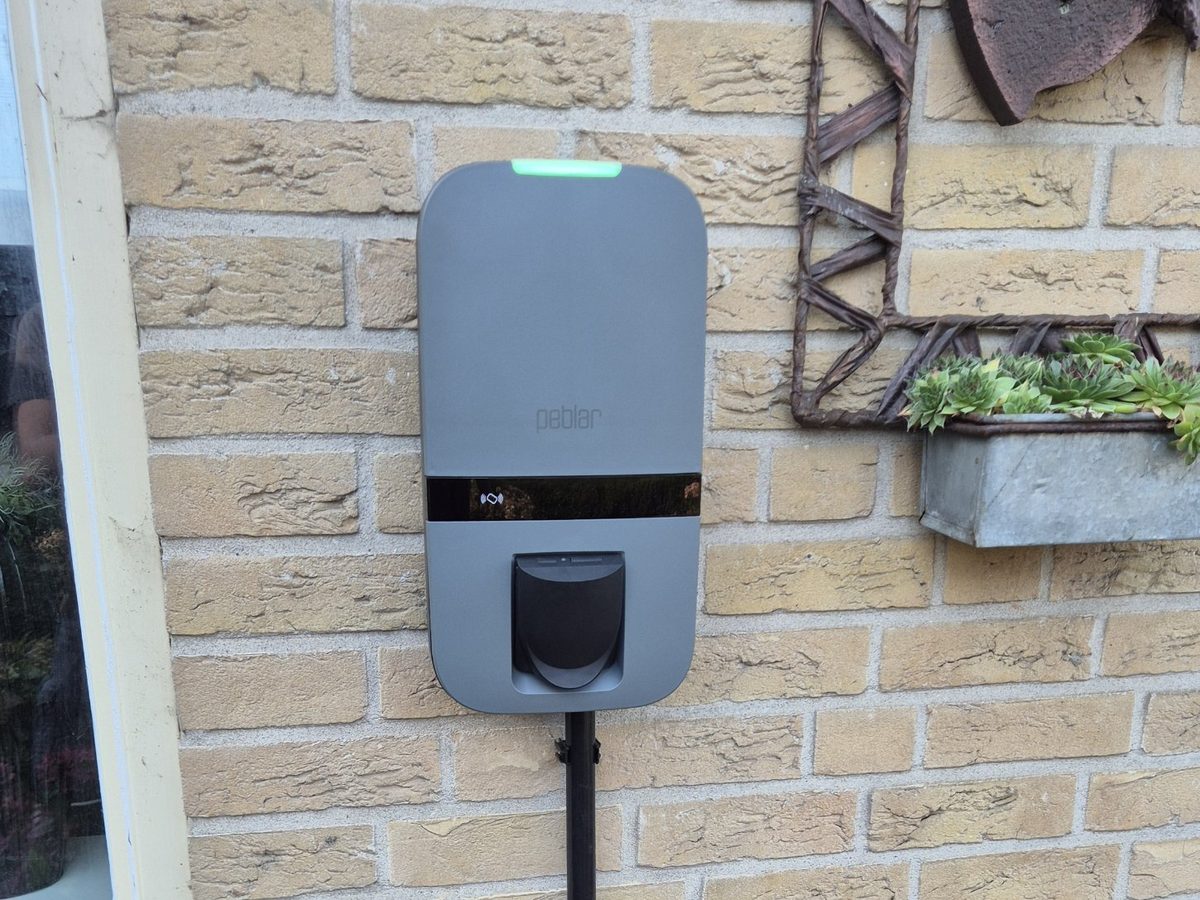 Peblar laadpaal aan de gevel in Tricht, met de voedingsbuis langs de muur